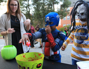Sophomore Caroline Davis looks on as Captain America plays the “ducks in guts” game at the trick-or-treat party.