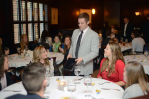 Hillel member Taylor Adwar explains the tradition of Hanukkah to dinner guests.