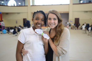 A Montlieu student and HPU sophomore Caroline Davis show off a butterfly craft made with coffee filters and pipe cleaners.