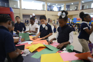 Children write thank-you letters to loved ones, donning their butterfly bows and bow-ties.