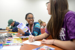 Senior Janae Werdlow decorating a card for elementary students.