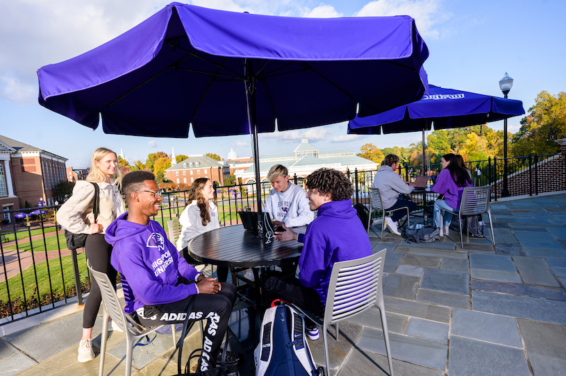 students studying outdoors under umbrellas