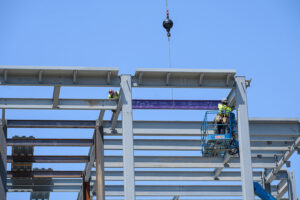 A topping-out ceremony was held on July 15 to celebrate the last steel beam being installed on the new law and dental buildings. Individuals signed the purple beam before it was installed.