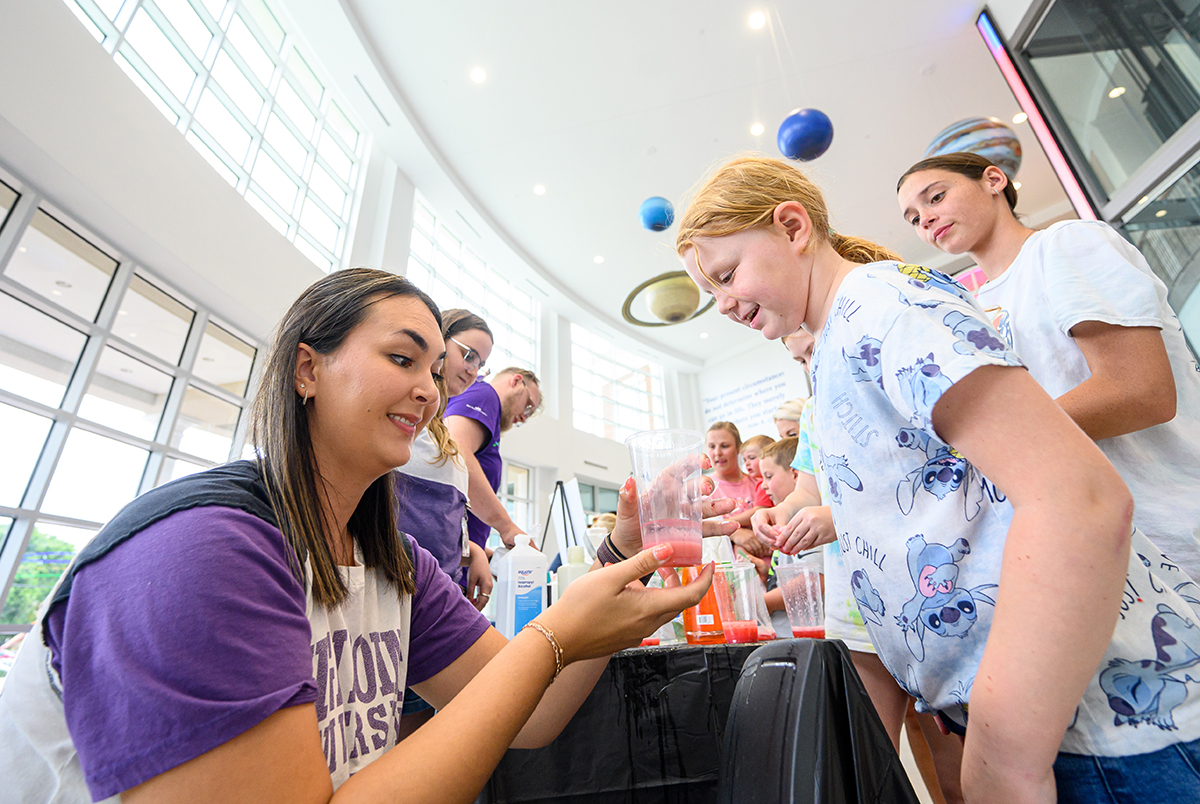 Carlee Logan, a sophomore neurology and biology major, mixed a strawberry DNA treat for children to taste.