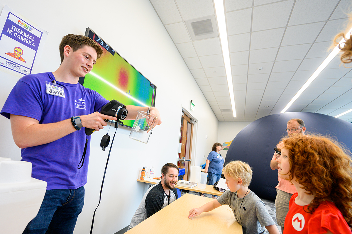 Jack Moreland, a sophomore physics and biochemistry major from Dallas, Texas, demonstrated and explained the thermal infrared camera’s capabilities. Behind him, the mobile planetarium allowed families to view stars, planets and constellations projected inside the dome.