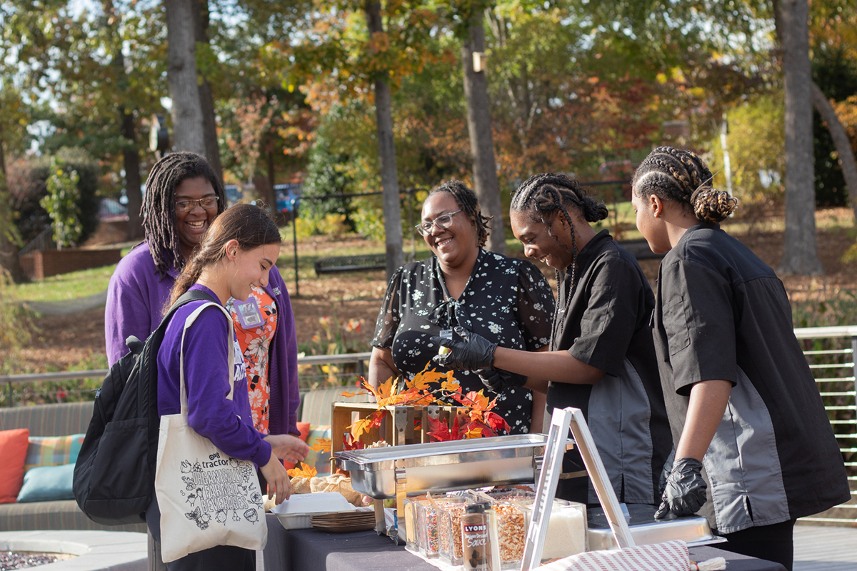 Panthers Commons dining team members smiled as they served a student at the 2023 Fall Festival.