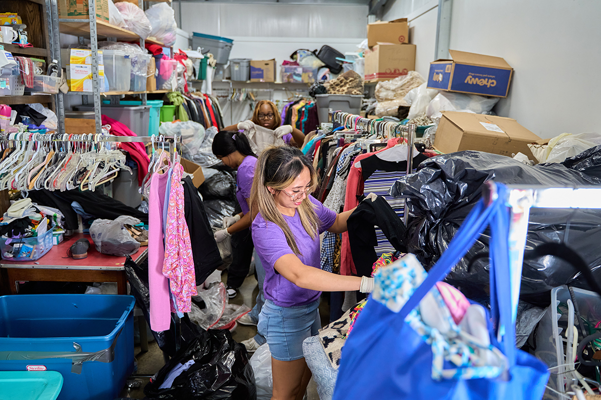 HPU pharmacy students Czarina Sobejana (front), Saniya Dalsaniya and Jordan Williams sorted clothing at West End Ministries thrift store. 