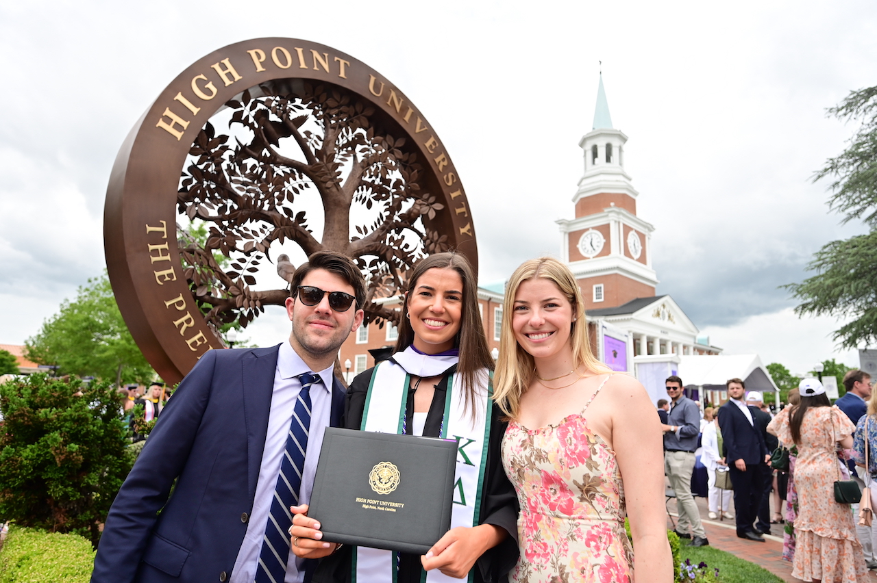 Commencement, people in front of tree sculpture