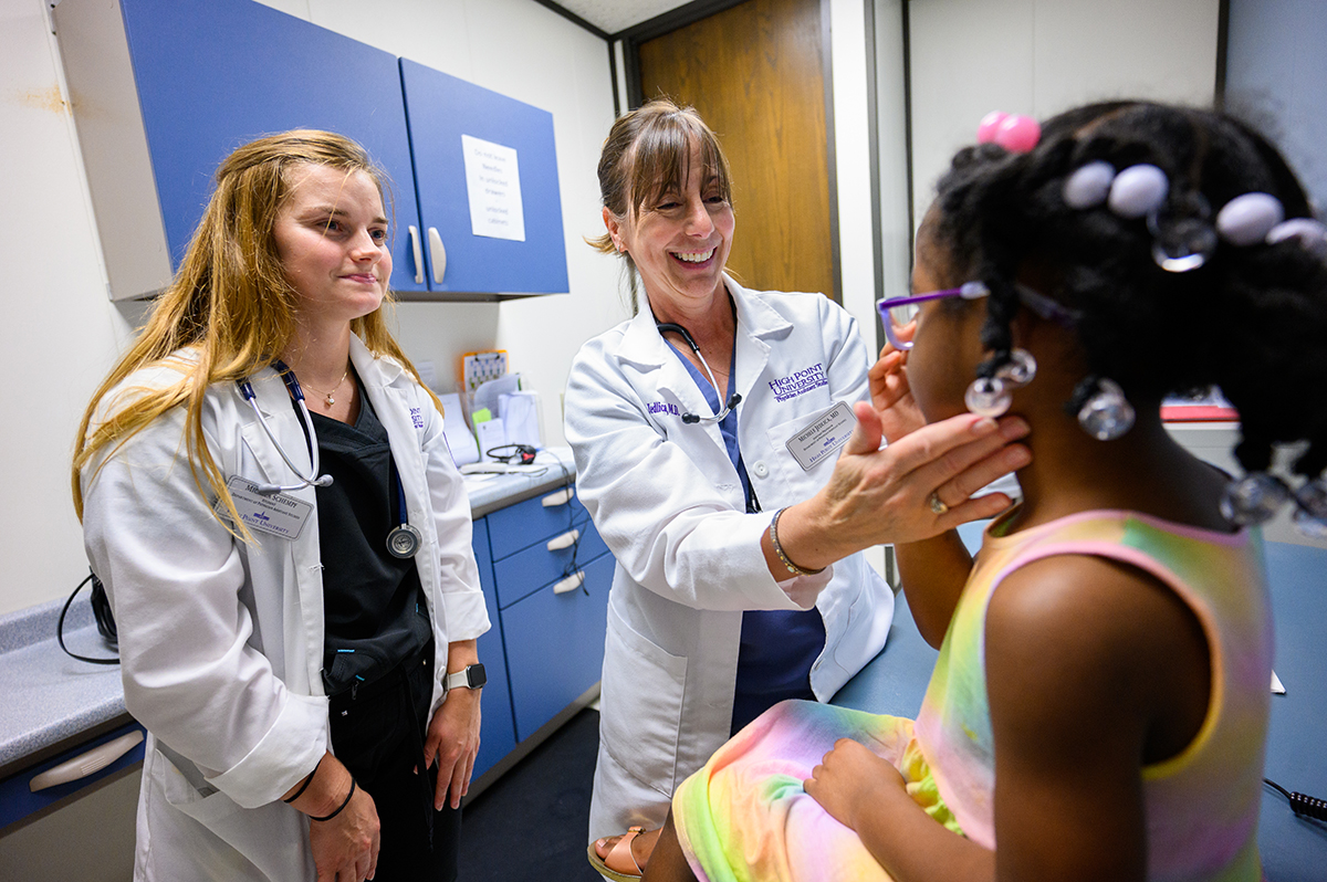 Physician Assistant student Michela Schempf and Dr. Michele Jedlica, assistant professor in the Department of Physician Assistant Studies, examine a child in a local clinic.