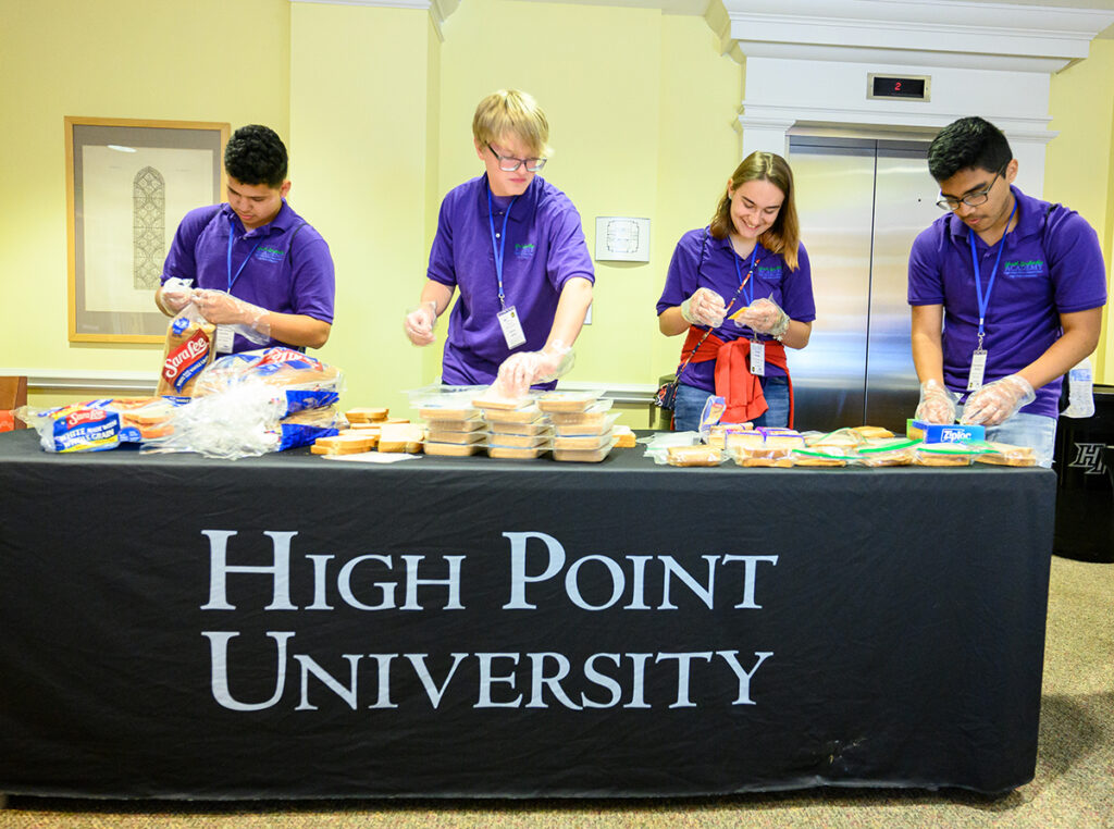 Youth Leadership Academy participants are pictured preparing meals to serve at Open Door Ministries, a homeless shelter for men in High Point.