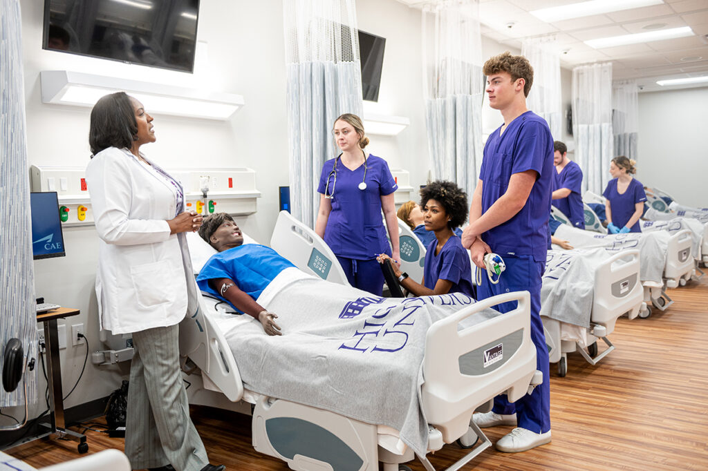 HPU Nursing Dean Dr. Racquel Ingram is pictured working with students in the school's 16-bed skills lab.