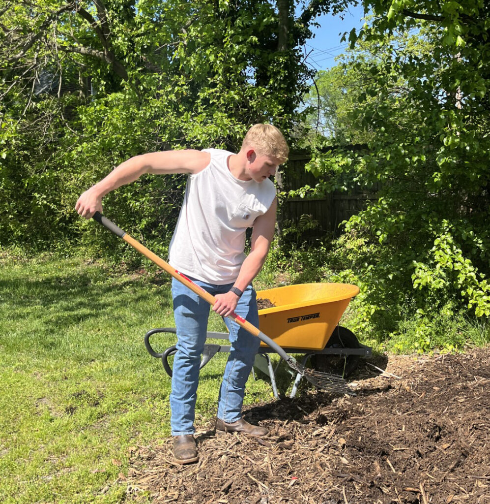 HPU Board of Stewards member Patrick Parker spreads dirt with a rake at West End Ministries’ community garden. 