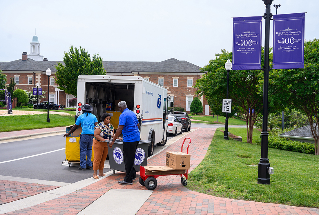 Marshall loads boxes of food donations into the postal truck for the National Association of Letter Carriers’ Stamp Out Hunger food drive as Harvey and Barnes clear another bin.