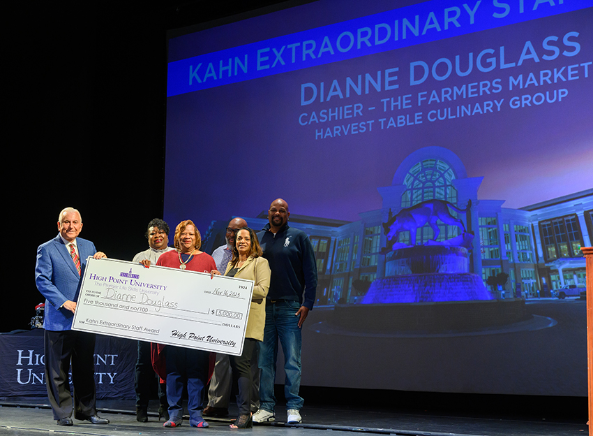 Qubein presents the Kahn Extraordinary Staff Award to Dianne Douglass, a cashier at the Farmer’s Market, whose family joined her on stage.