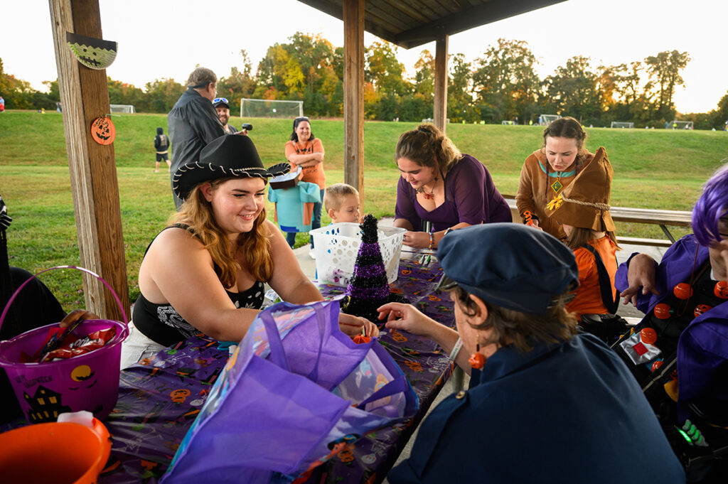 HPU student Larissa Paddock, left, and other students assist children and attendees with making Halloween-themed arts and crafts.