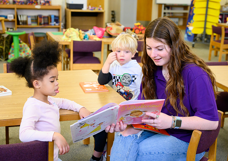 Trammell Miller, an elementary education major with minors in studio arts and special education from Emerald Isle, North Carolina, reads with kindergarten students.