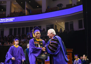 Qubein and an HPU graduate shared a laugh as she crossed the stage at Commencement.