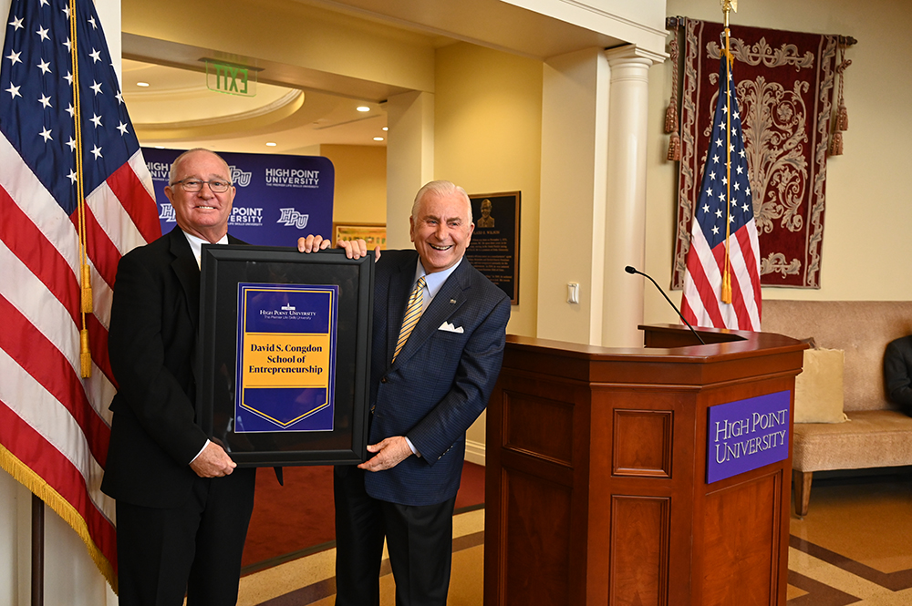 From left, David S. Congdon, executive chairman of Old Dominion Freight Line Inc., received the banner for the new school of entrepreneurship from HPU President Qubein. 