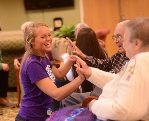 Jessie Drew shares congratulatory handshakes and high fives with the senior citizens for the completion of two poems in the session.