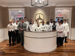 A group that includes three High Point University students poses for a photograph inside Firethorn Cabin, which is a hospitality cabin at Augusta National that is sponsored by Mercedes-Benz.