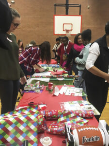 HPU students and community members wrap gifts at the Impact Christmas event. 